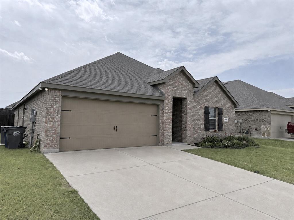 Brick facade, attached two-car garage, concrete driveway, and gabled roofline