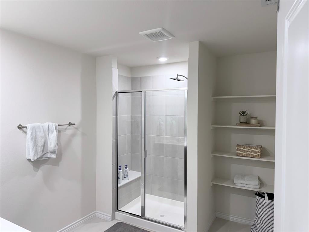 Enclosed shower with a built-in bench, glass door, and tile surround Enclosed shower with a built-in bench, glass door, and tile surround