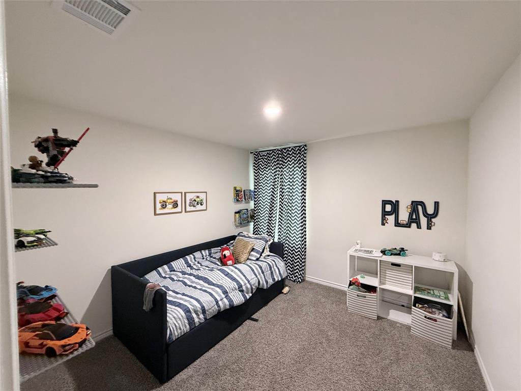 Recessed ceiling lighting, wall-mounted shelving, white wall paint, patterned window treatments, and gray carpeting