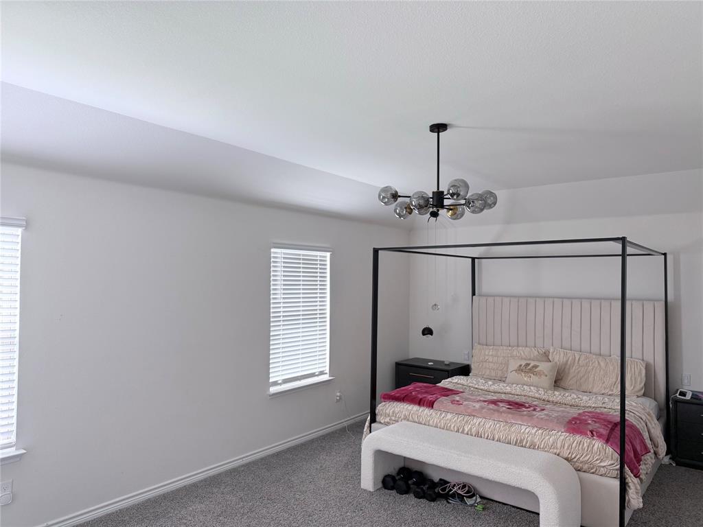 Recessed ceiling, dual windows with blinds, and a contemporary chandelier Recessed ceiling, dual windows with blinds, and a contemporary chandelier