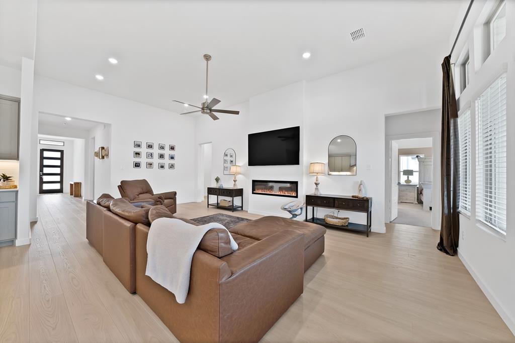 Very spacious inviting family room with an electric fireplace and a wall of windows.