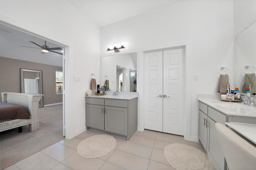 Dual vanity with gray cabinetry and white countertops.