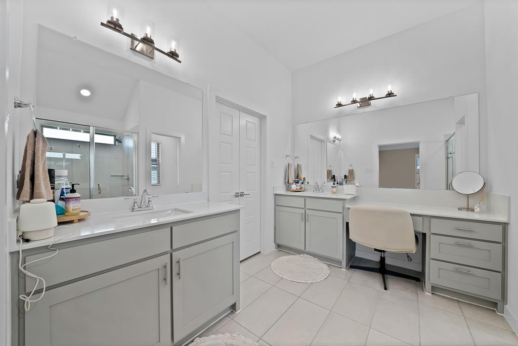 Dual vanities with undermount sinks, integrated vanity counter, light gray cabinetry, and tile flooring.