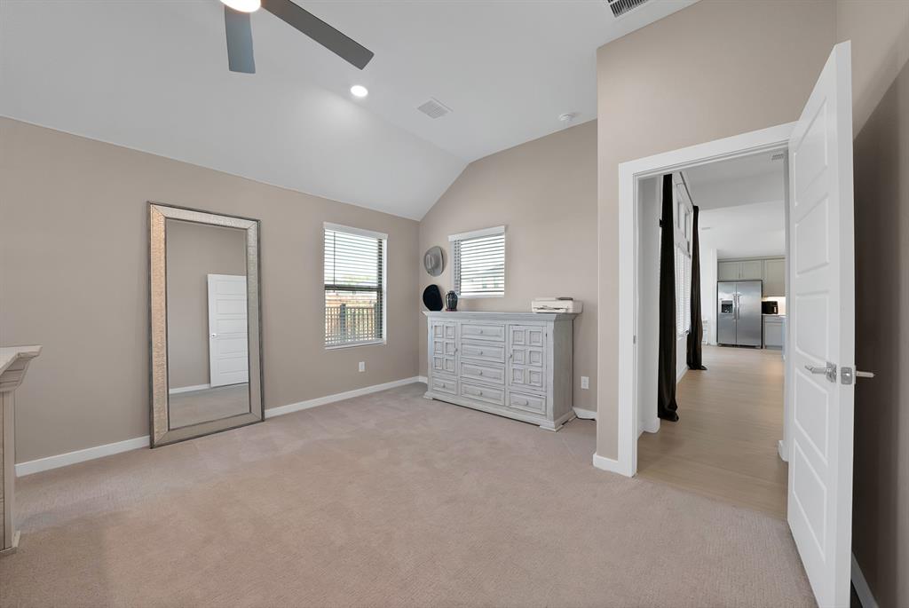 Vaulted ceiling with recessed lighting and ceiling fan that adorn this primary retreat.