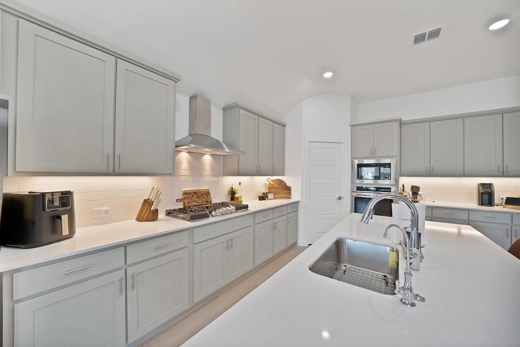 Stainless steel appliances with a beautiful backsplash keeping this kitchen sleek.