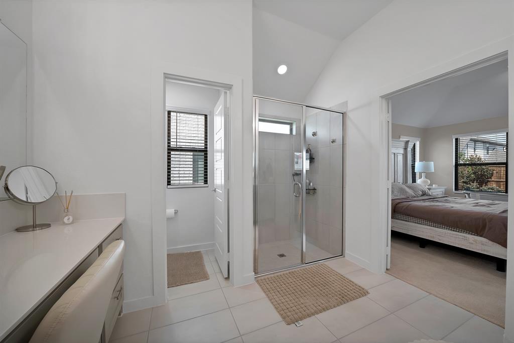 Vaulted ceilings carry through into the primary bathroom.