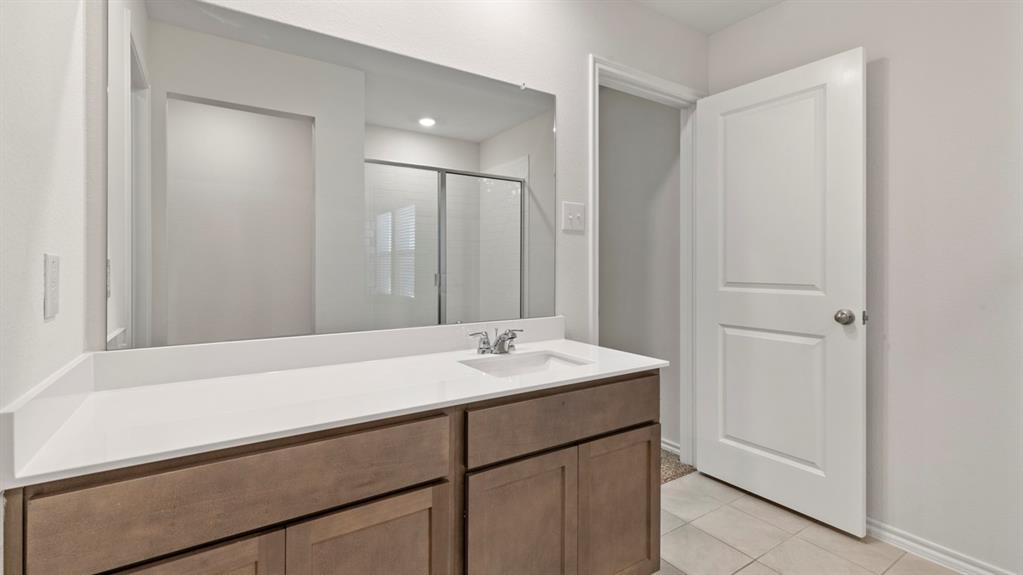 Contemporary vanity with a white countertop and integrated sink, chrome faucet, and wood-finish cabinetry