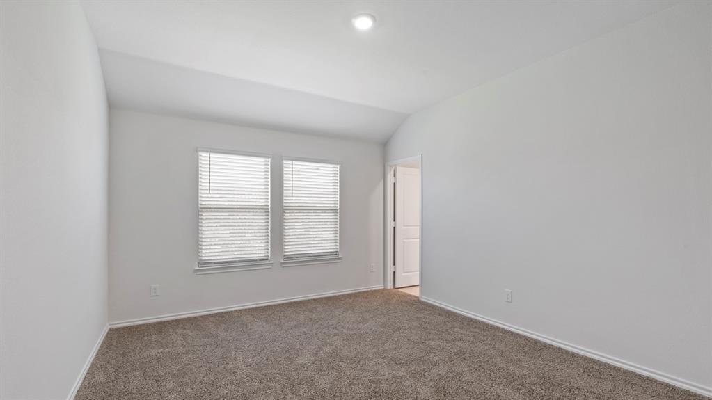 Carpeted flooring, vaulted ceiling, recessed lighting, and dual windows with blinds