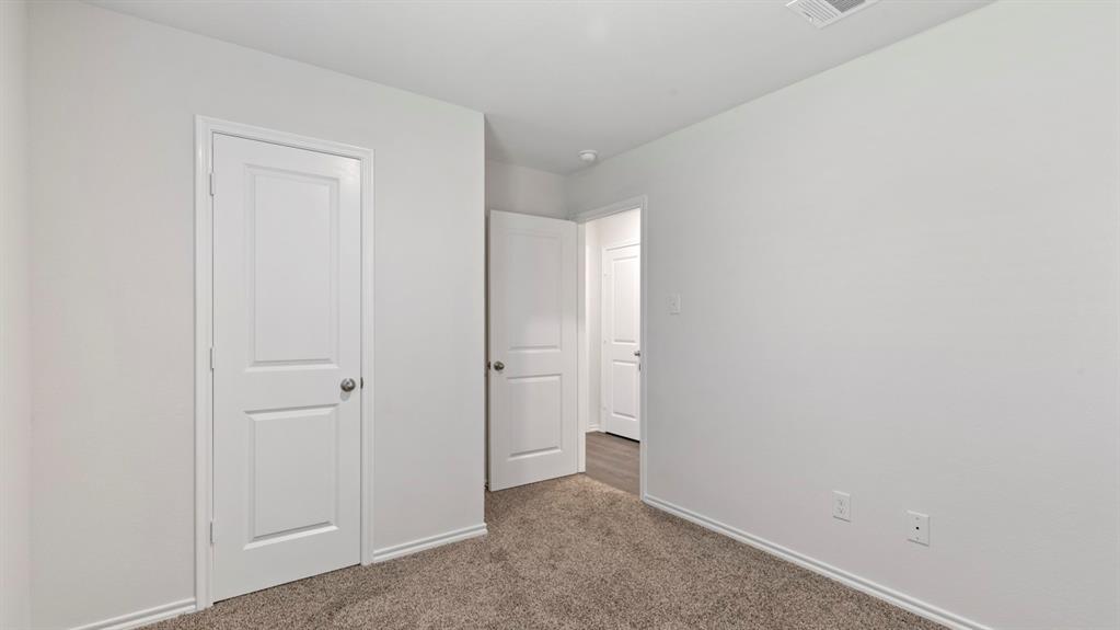 Neutral tone wall paint, paneled interior doors, and carpet flooring