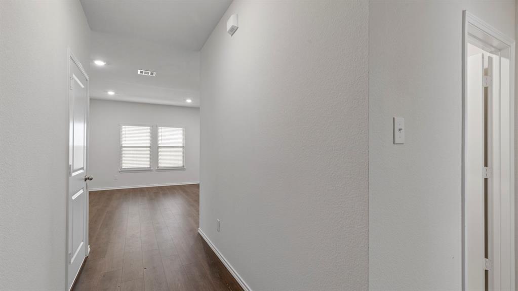 Recessed lighting, wood-finish flooring, white paneled doors, and dual windows with blinds