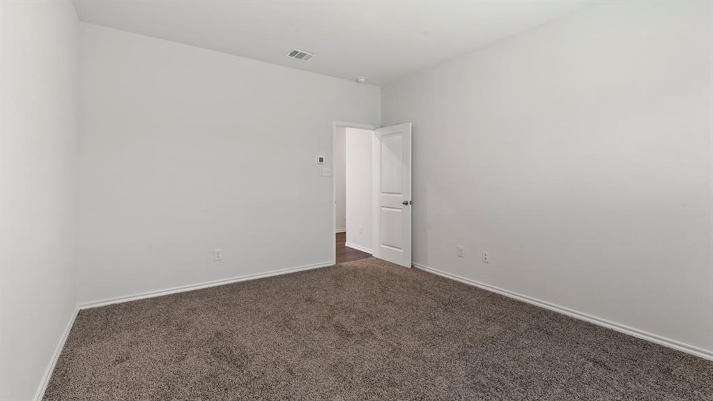 Neutral wall paint, carpet flooring, and a paneled interior door