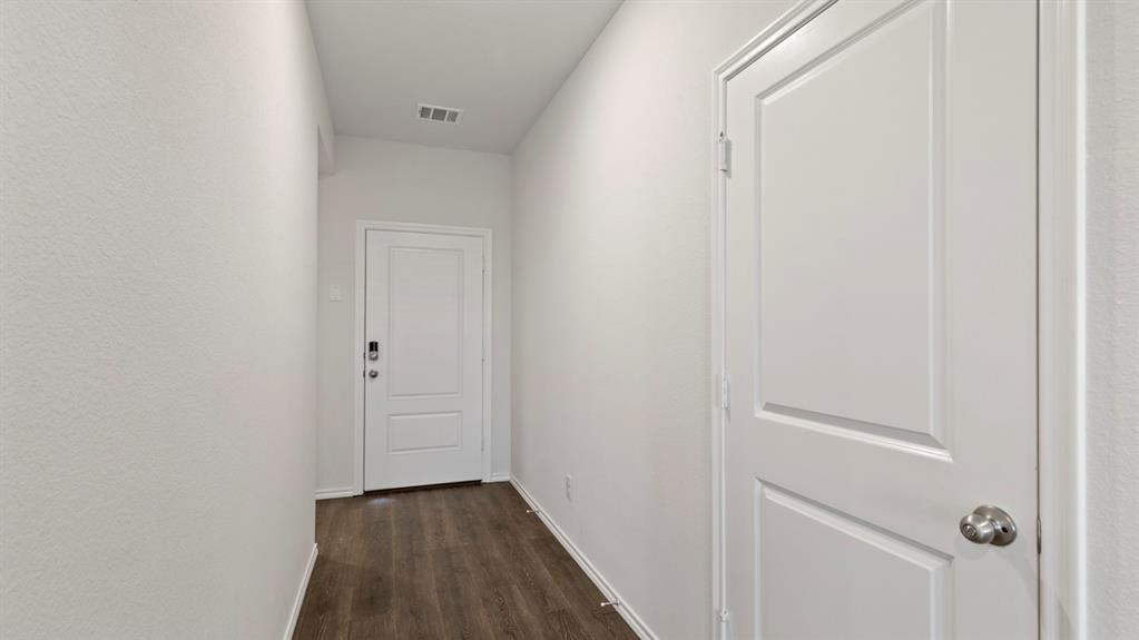Wood-finish flooring with white baseboards, white paneled doors, and light-toned walls