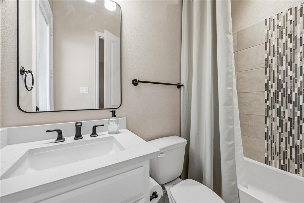 Vanity with a white countertop and rectangular sink, matte black faucet, and a framed mirror