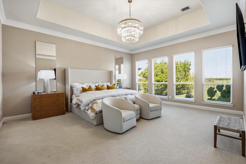 Expansive primary suite overlooking the serene pool and greenspace.