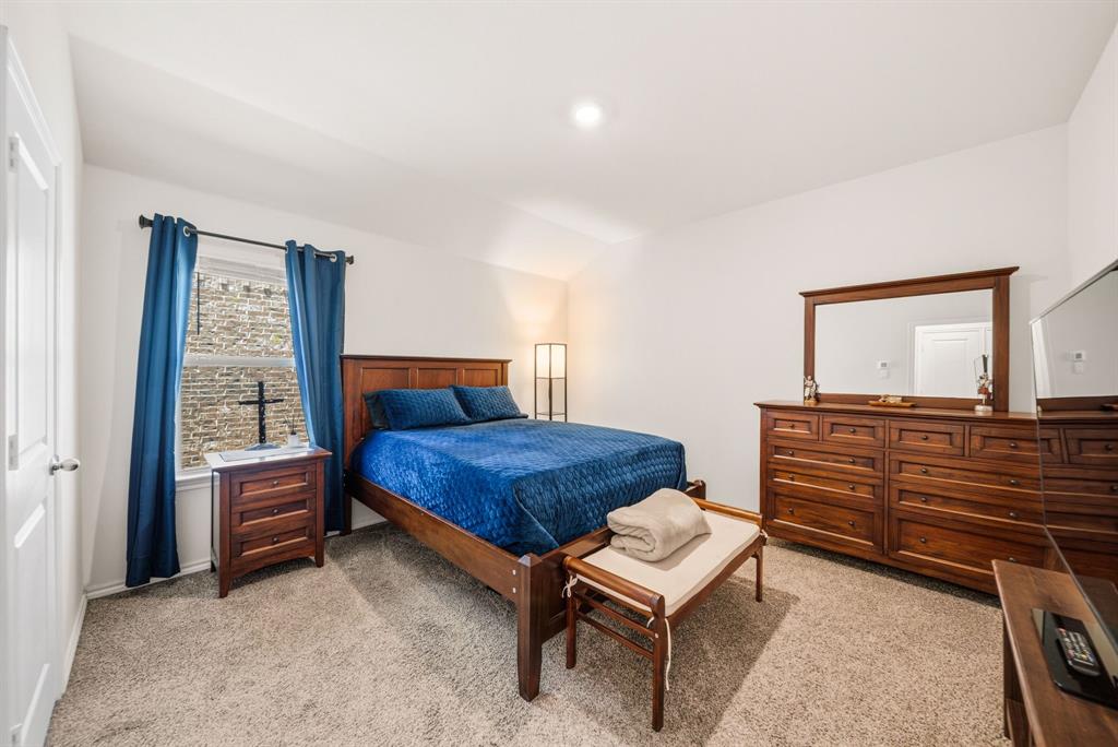 Recessed lighting, light-colored carpet, white walls, and a window with a dark frame