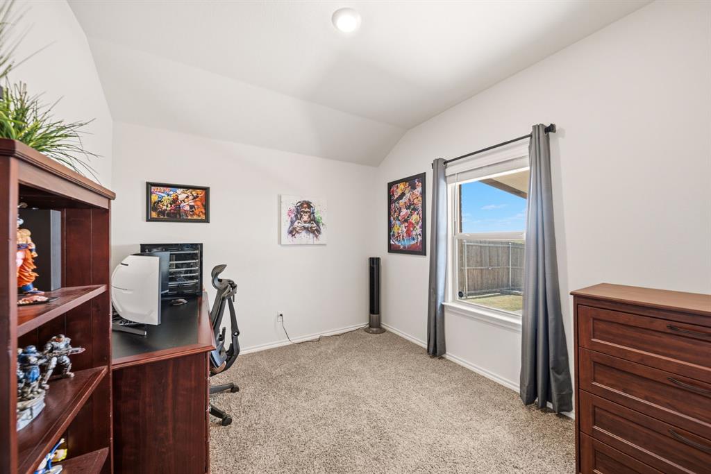 Carpeted flooring, vaulted ceiling, and a single window with a backyard view