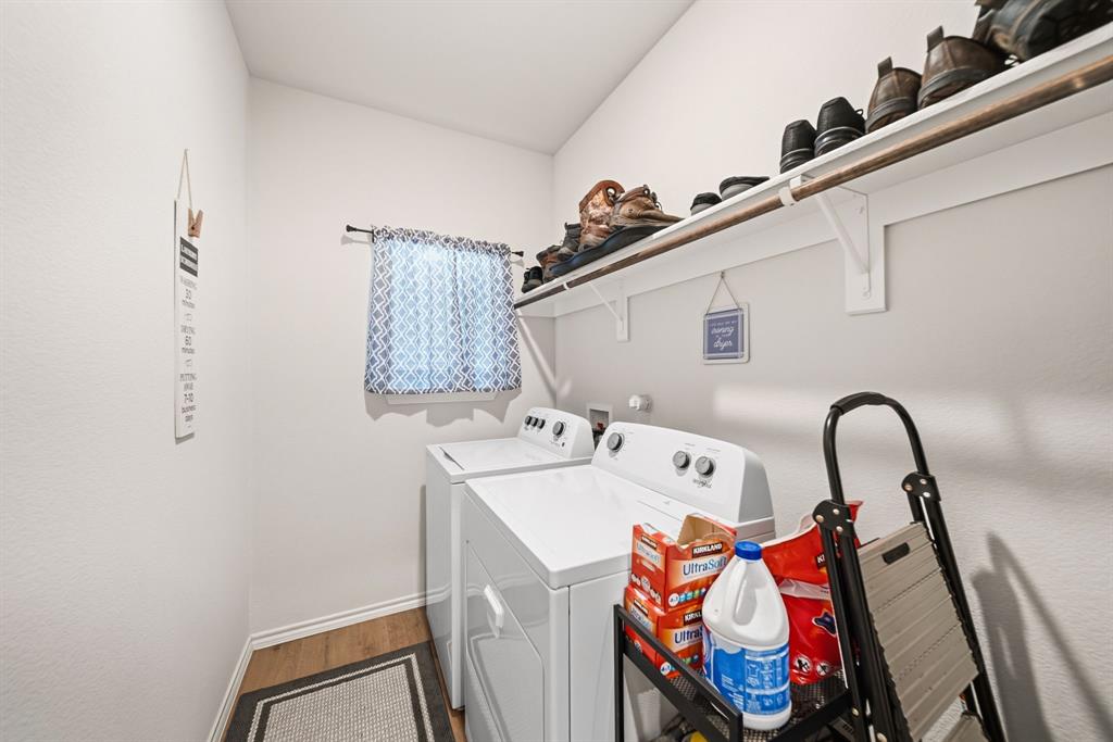 Built-in shelving with hanging rod, window with natural light, and wood-finish flooring