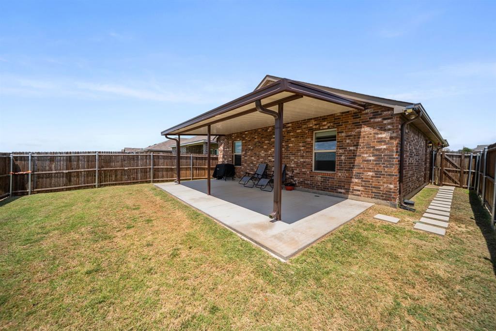 Covered patio featuring a concrete slab and a brick exterior