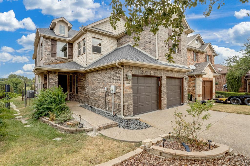 Brick exterior with stone accents, dormer windows, and a two-car garage