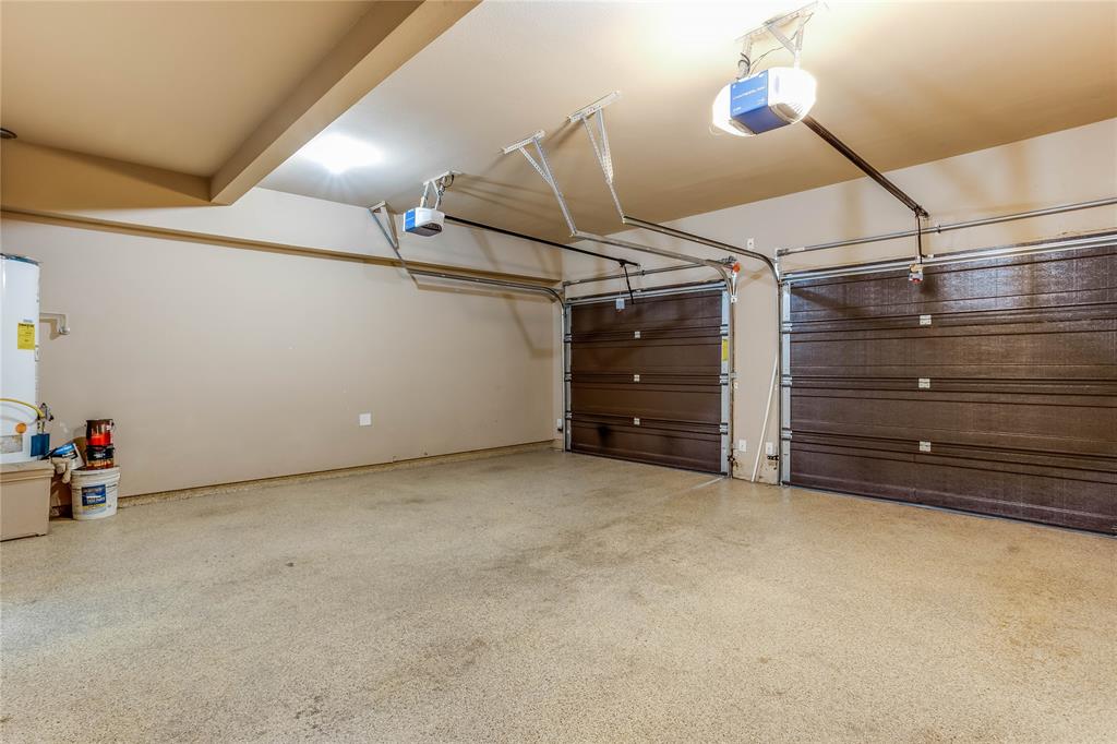 Two-car garage featuring automatic openers, textured doors, and a durable speckled floor finish