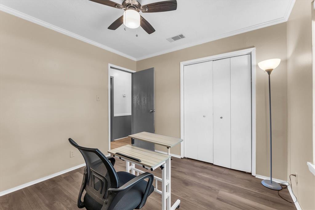 Wood-finish flooring, ceiling fan, white bi-fold closet doors, and crown molding