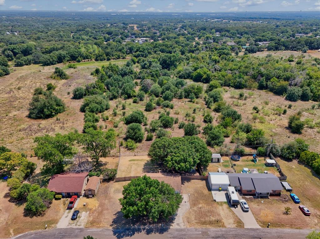 Expansive land parcel featuring existing residential structures, mature trees, and natural vegetation