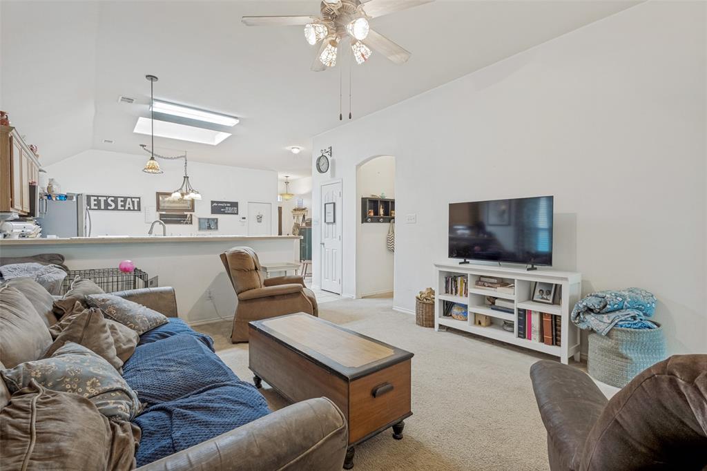 Vaulted ceilings enhance the living space, featuring a ceiling fan.