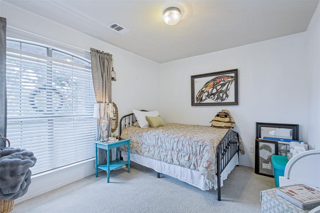 Carpeted flooring, arched window, and ceiling-mounted light fixture