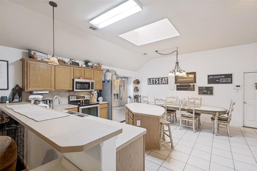 Kitchen featuring wood-finish cabinetry, stainless steel appliances, and a breakfast bar