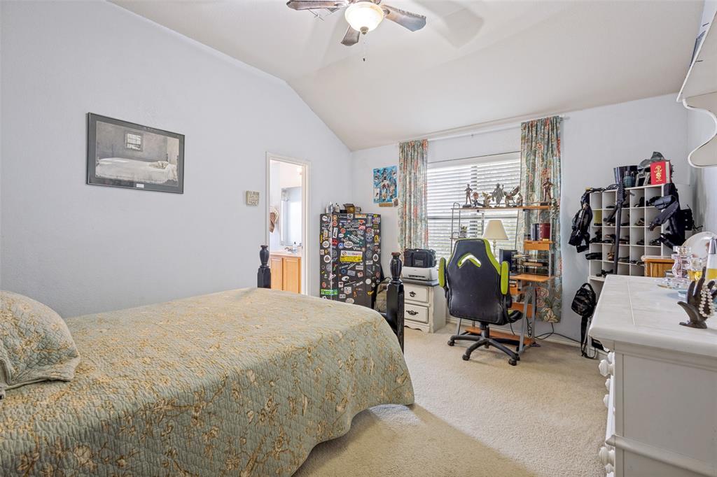 Vaulted ceiling featuring a ceiling fan with integrated lighting, carpet flooring, and a window with blinds