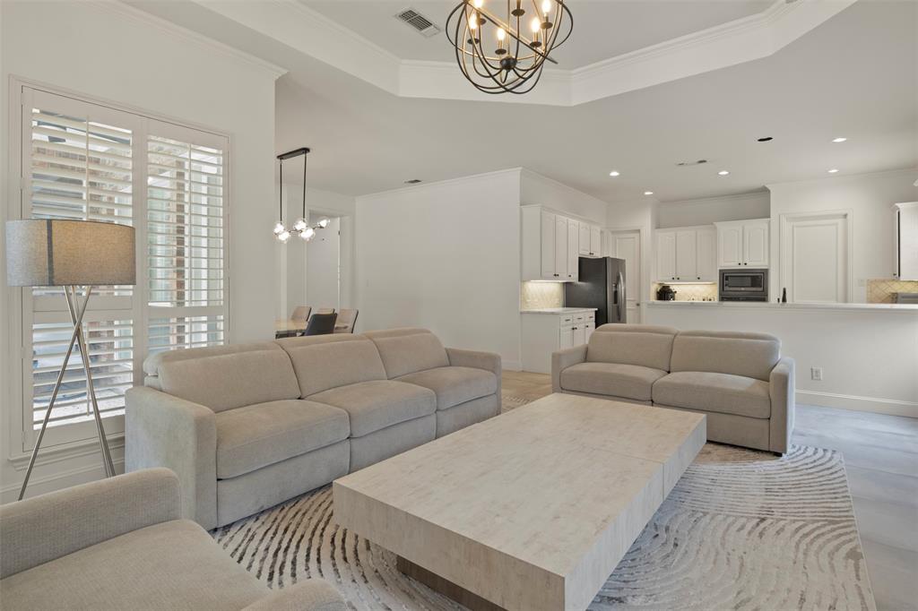 Recessed lighting, crown molding, plantation shutters, built-in kitchen cabinetry, and a tray ceiling