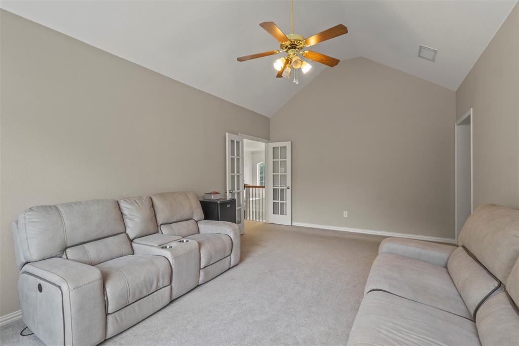Vaulted ceiling with a ceiling fan, neutral wall paint, and carpet flooring