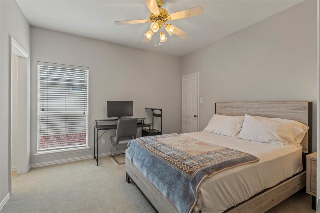 Vaulted ceiling featuring a ceiling fan, window with blinds, and light-colored carpeting