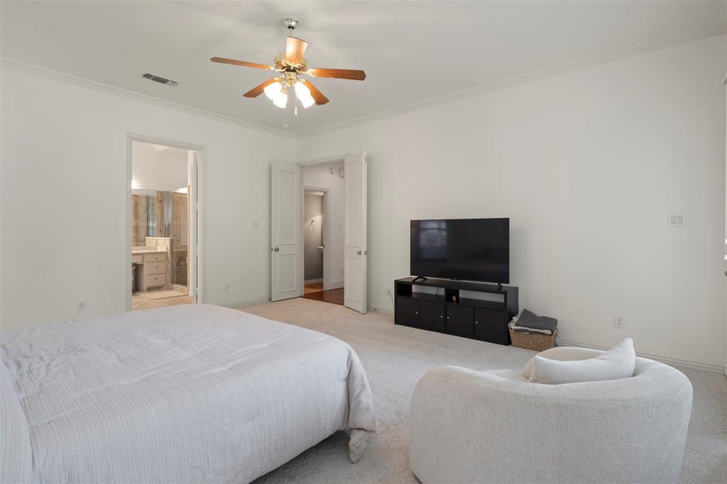 Recessed ceiling fan with wood-finish blades, white crown molding, and light-toned carpeting
