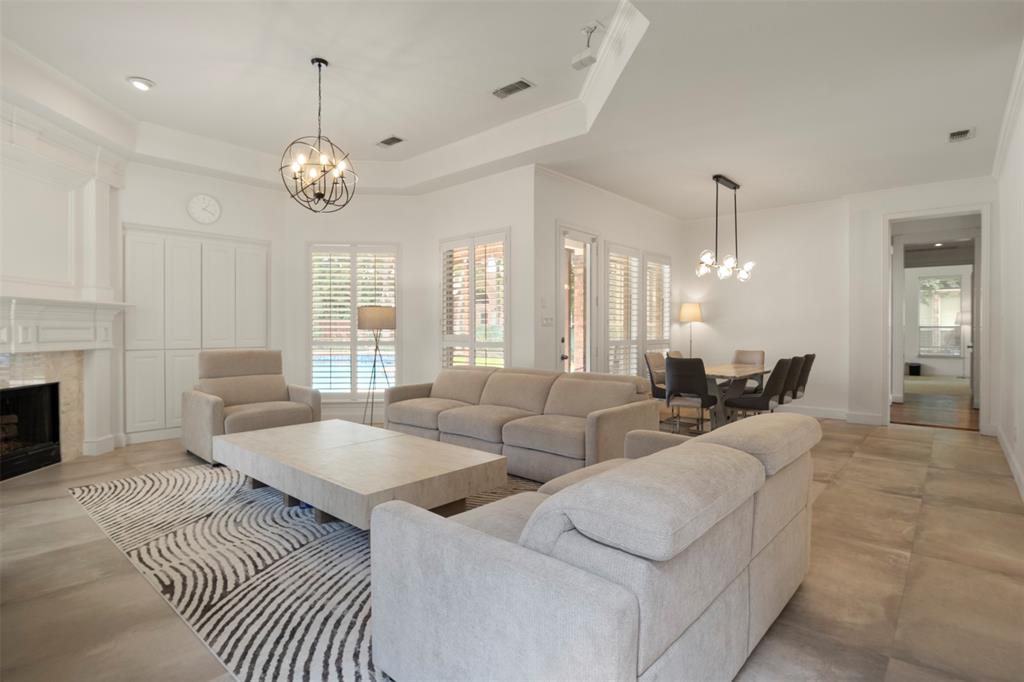 Spacious living area featuring a fireplace with a mantel, built-in cabinetry, and tile flooring