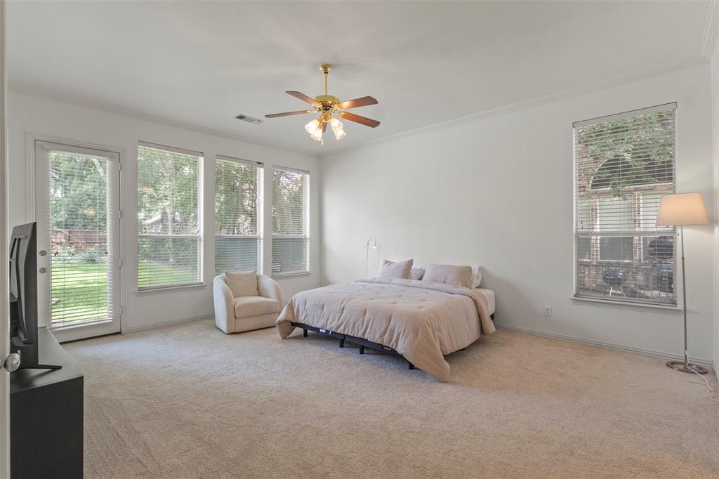 Wall-to-wall carpeting, multiple windows with blinds, ceiling fan, and crown molding