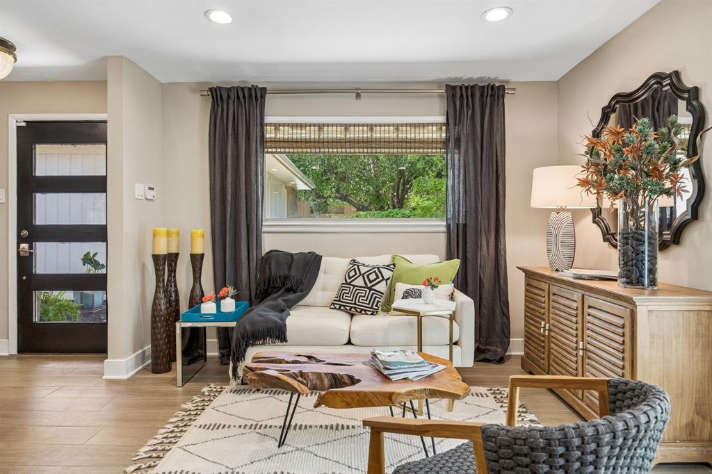 Wood-finish flooring throughout, recessed ceiling lighting, and a modern entry door with horizontal glass panels