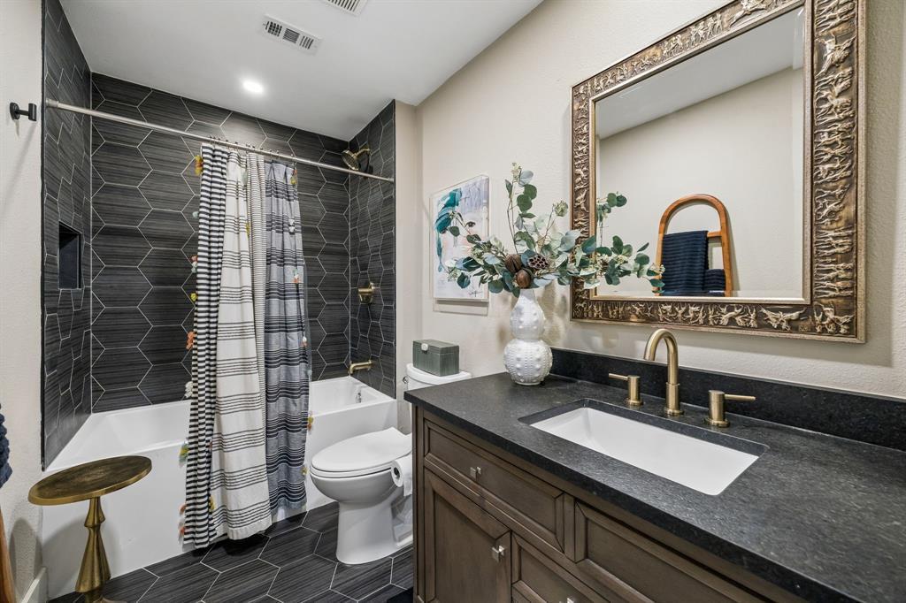 Hexagonal tile flooring and shower surround with Black granite countertops
