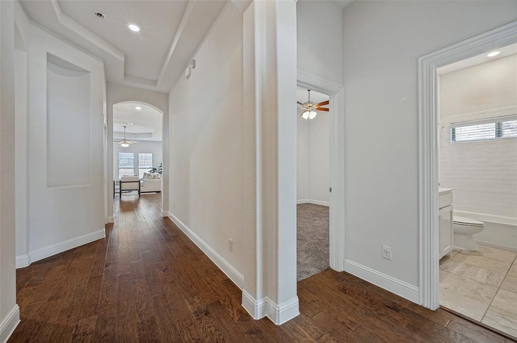 Hallway featuring wood-finish flooring, recessed lighting, arched doorways, and a built-in wall niche