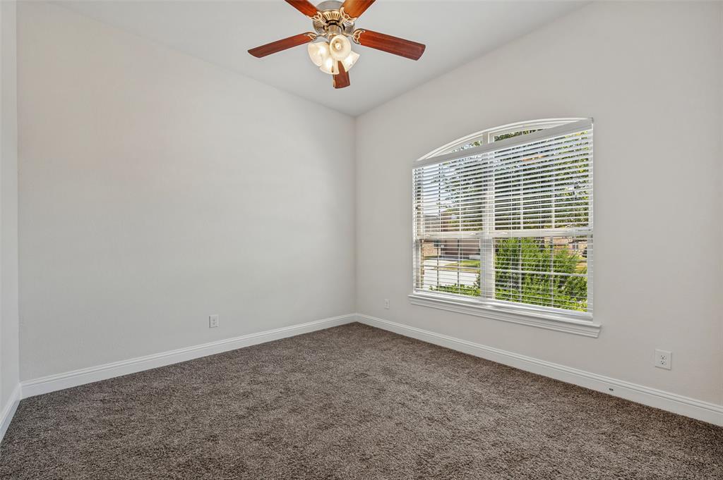 Vaulted ceiling with a wood-finish ceiling fan, arched window with horizontal blinds, and carpeting