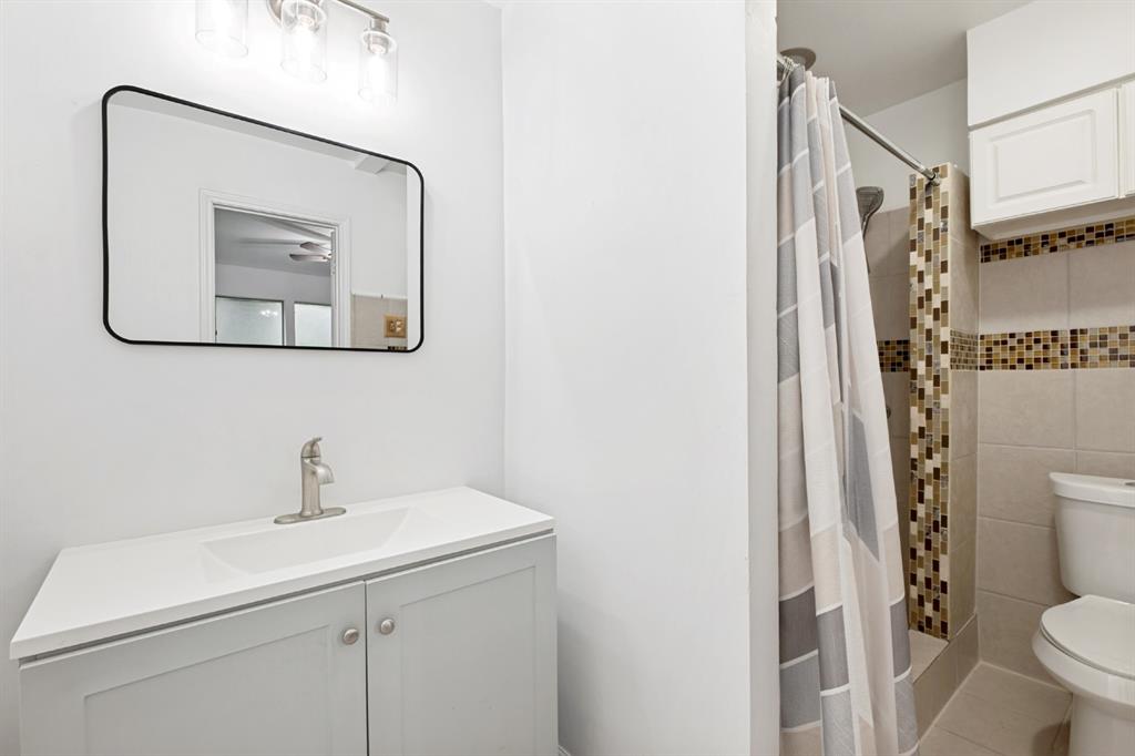 Clean and functional bathroom featuring a white vanity with dual cabinet storage, rectangular sink, and brushed nickel faucet