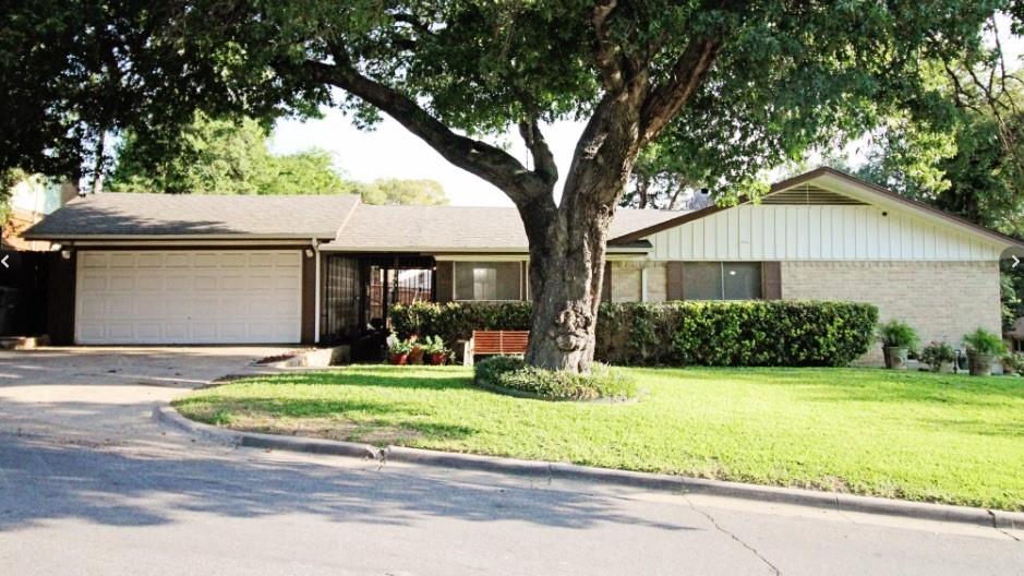 Single-story residence featuring a brick and siding exterior, attached two-car garage, and a sloped roofline