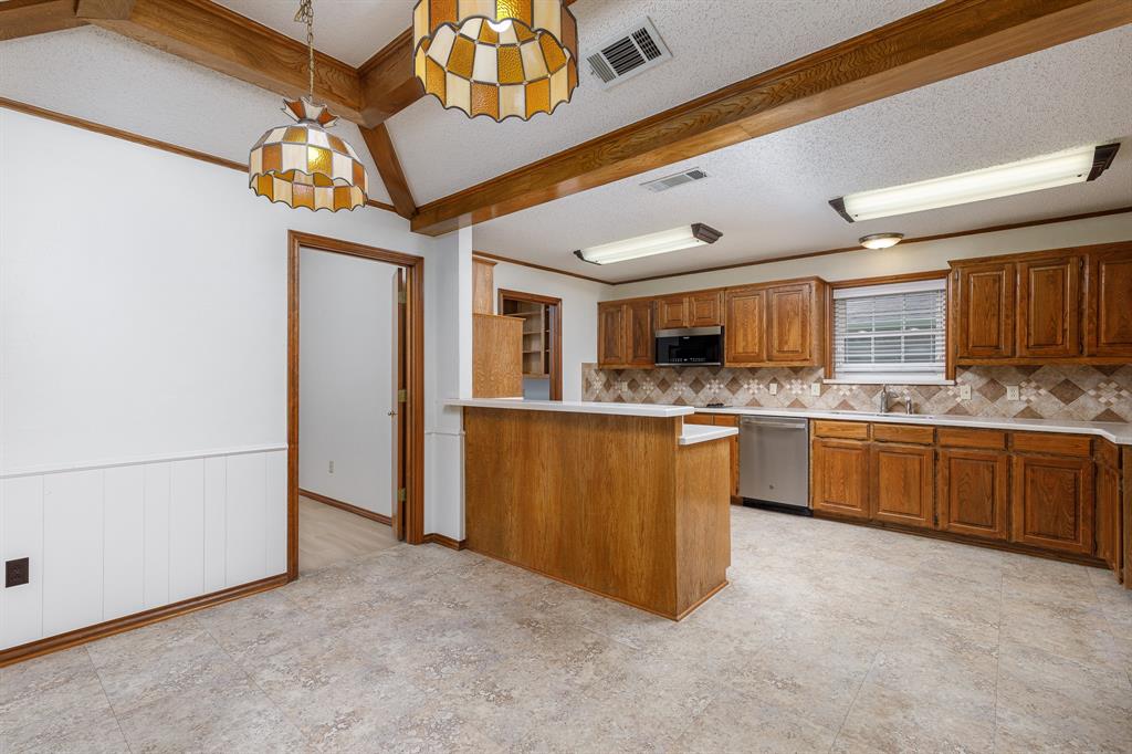 Kitchen with wood cabinetry, stainless steel appliances, and a breakfast bar