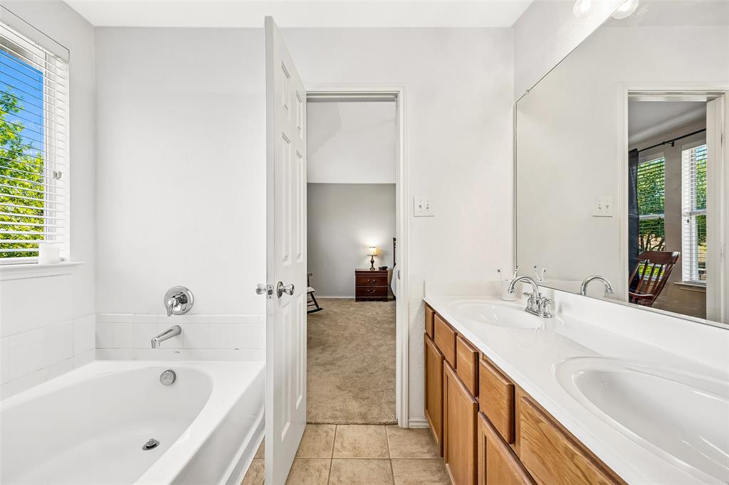Dual vanity with integrated sinks, wood-finish cabinetry, and a full-width mirror