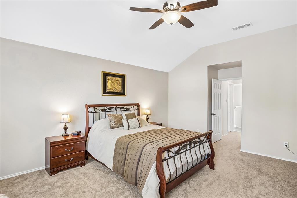 Vaulted ceiling with an attached ceiling fan, neutral carpet, and a paneled interior door