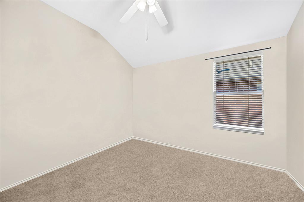 Vaulted ceiling with a ceiling fan, carpeted flooring, and a single window with blinds