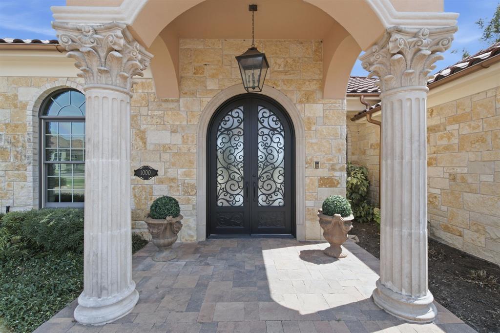 Stone facade with arched entryway and ornate wrought iron double doors