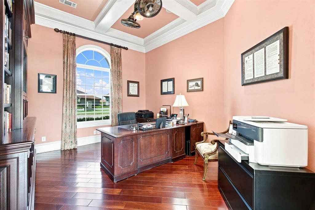 Arched window, wood-finish flooring, built-in shelving, coffered ceiling, and crown molding
