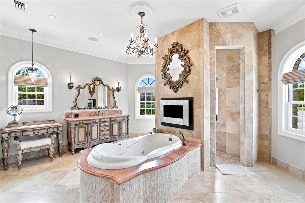 Freestanding jetted bathtub with a mosaic tile surround and red countertop