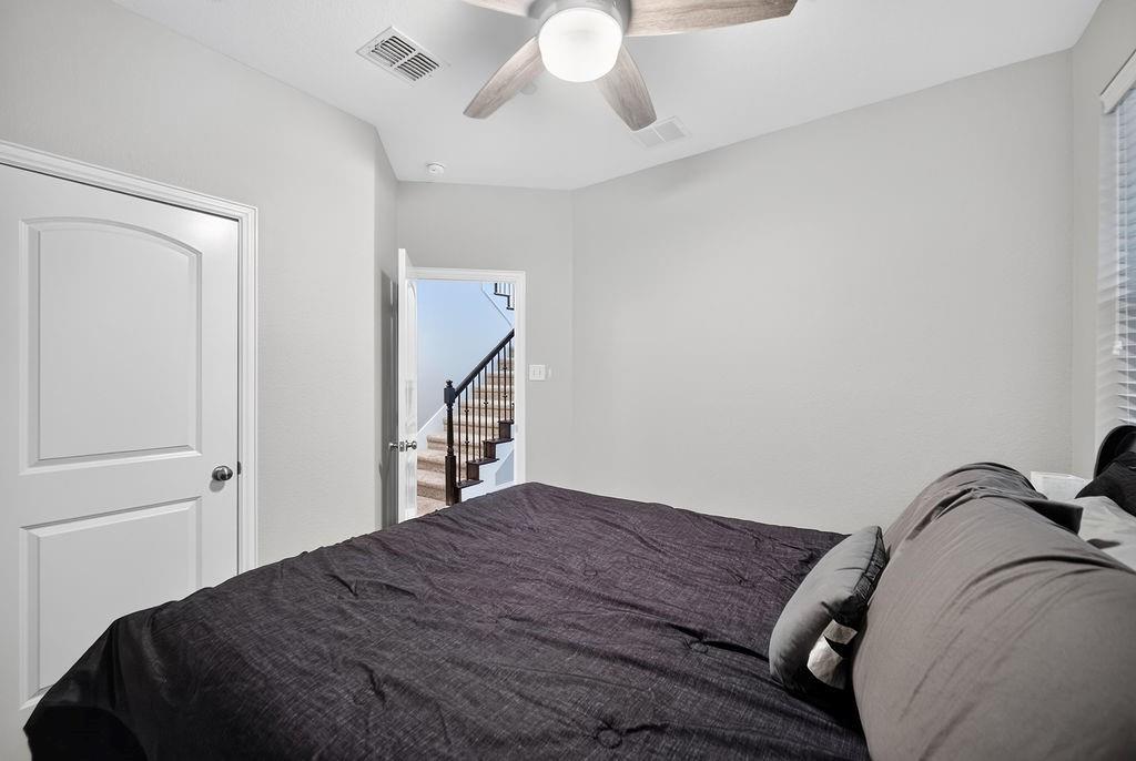 White walls, white arched-panel door, and a ceiling fan with light fixture